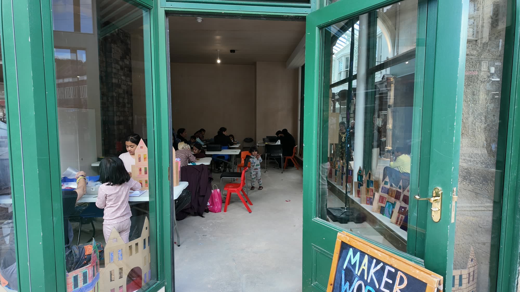 A maker workshop with green-framed doors open in the Dewsbury arcade