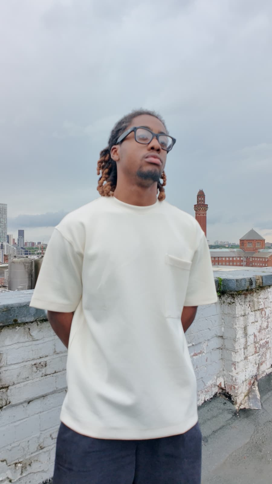 Model in a cream oversized t-shirt photographed on a rooftop