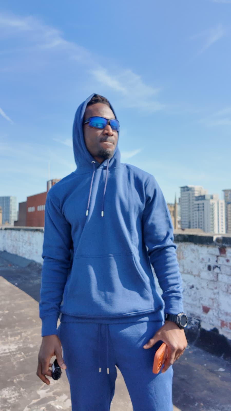 Model in a blue hooded tracksuit against the town skyline