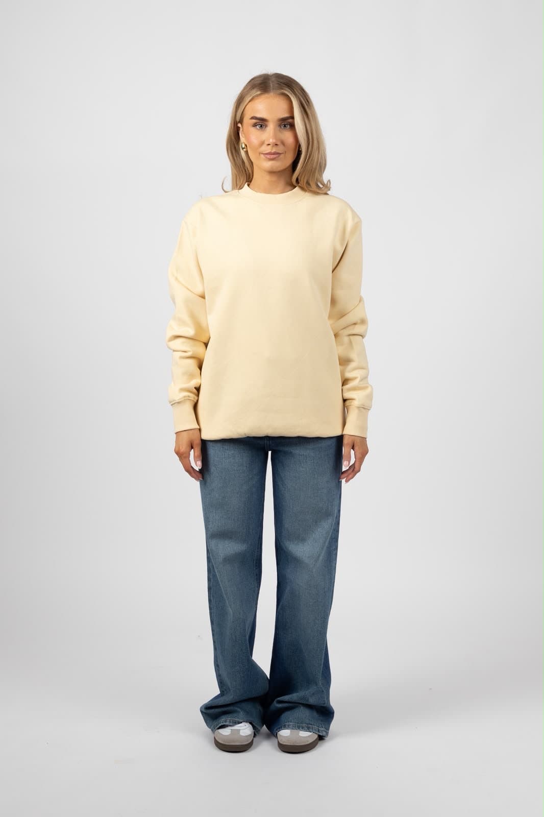 Model in a butter-cream crewneck sweatshirt, full length